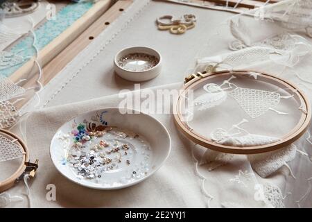 Lieu de travail d'un brodeur avec des cadres de broderie, broderie ange, perles Banque D'Images