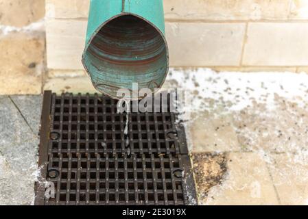 Vidange de l'eau de pluie. Gouttière du toit. L'eau est versée de la gouttière dans la grille. Banque D'Images