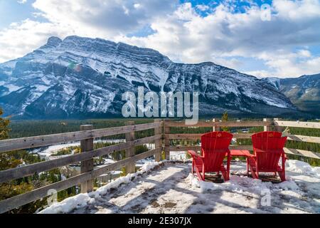 Chaise rouge, vue sur le Mont Rundle en hiver enneigé par temps ensoleillé. Parc national Banff magnifique paysage. Hoodoos Viewpoint, Rocheuses canadiennes. Banque D'Images