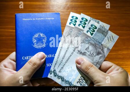 Sorocaba, Brésil. 15 janvier 2021. Main tenant trois 200 bons de REais et carte de visite. Avec la fin de l'aide d'urgence de 600 reais en janvier 2021, environ 48 millions de Brésiliens ont été touchés. Environ 275 milliards de dollars R ont été versés en 2020 à 68 millions de personnes. Credit: Cadu Rolim/FotoArena/Alay Live News Banque D'Images