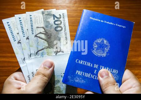 Sorocaba, Brésil. 15 janvier 2021. Main tenant trois 200 bons de REais et carte de visite. Avec la fin de l'aide d'urgence de 600 reais en janvier 2021, environ 48 millions de Brésiliens ont été touchés. Environ 275 milliards de dollars R ont été versés en 2020 à 68 millions de personnes. Credit: Cadu Rolim/FotoArena/Alay Live News Banque D'Images