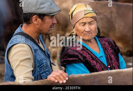 Karakol, Kirghizistan - 14 juillet 2019 : homme et femme au marché de l'élevage dans la ville de Karakol au Kirghizistan. Banque D'Images