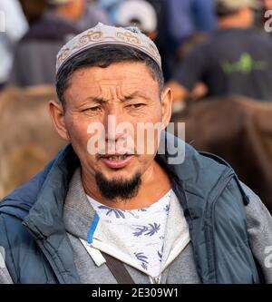 Karakol, Kirghizistan - 14 juillet 2019 : l'homme au marché de l'élevage avec beaucoup de gens et d'agriculteurs dans la ville de Karakol au Kirghizistan. Banque D'Images