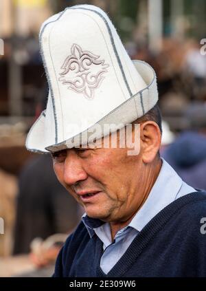 Karakol, Kirghizistan - 14 juillet 2019 : l'homme au marché de l'élevage avec beaucoup de gens et d'agriculteurs dans la ville de Karakol au Kirghizistan. Banque D'Images