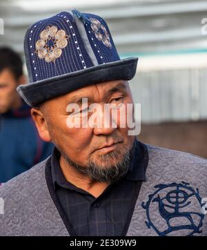 Karakol, Kirghizistan - 14 juillet 2019 : l'homme au marché de l'élevage avec beaucoup de gens et d'agriculteurs dans la ville de Karakol au Kirghizistan. Banque D'Images