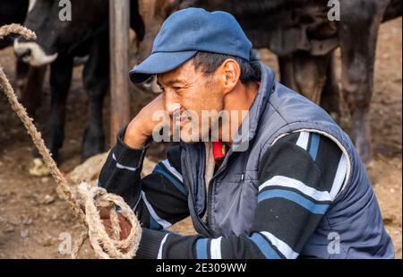 Karakol, Kirghizistan - 14 juillet 2019 : l'homme au marché de l'élevage dans la ville de Karakol au Kirghizistan. Banque D'Images