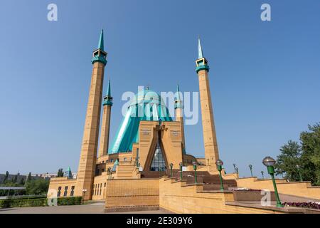 Pavlodar, Kazakhstan - 27 juillet 2020 : entrée de la mosquée Mashkhur Jusoup avec quatre minarets et toit bleu. Banque D'Images