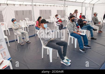 Quito, Équateur. 15 janvier 2021. Les personnes portant une protection de la bouche et du nez attendent d'être examinées dans une salle d'attente improvisée installée dans une tente devant l'hôpital IESS sur, puis emmenées dans la zone pour le prélèvement d'échantillons PCR. Les hôpitaux et les bureaux de santé en Équateur sont surchargés en raison de la pandémie de Corona et atteignent donc leurs limites. Crédit : Juan Diego Montego//dpa/Alay Live News Banque D'Images