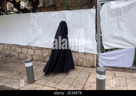 Un membre de la secte Haredi burqa aussi connue sous le nom de 'femmes' (groupe religieux juif, dans lequel les femmes juives ultra-orthodoxes prétendent que la modestie appelle une couverture de style burqa de tout le corps) marche à travers MEA Shearim, un quartier ultra-orthodoxe de Jérusalem-Ouest, Israël. Le Shalim, communément connu sous le nom de « culte burqa », est l'une des sectes les plus isolées et les plus dénigrées d'Israël, même parmi la population ultra-orthodoxe du pays. Banque D'Images