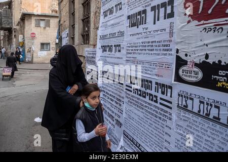 Un membre de la secte dite Haredi burqa (groupe religieux juif, dans lequel les femmes juives ultra-orthodoxes affirment que la modestie appelle une couverture burqa de tout le corps) marche avec ses enfants à travers MEA Shearim un quartier ultra-orthodoxe de Jérusalem-Ouest, Israël. Le Shalim, communément connu sous le nom de « culte burqa », est l'une des sectes les plus isolées et les plus dénigrées d'Israël, même parmi la population ultra-orthodoxe du pays. Banque D'Images