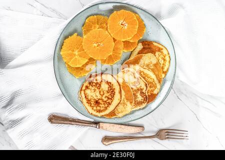 Crêpes américaines et tranches d'orange sur fond de marbre Banque D'Images