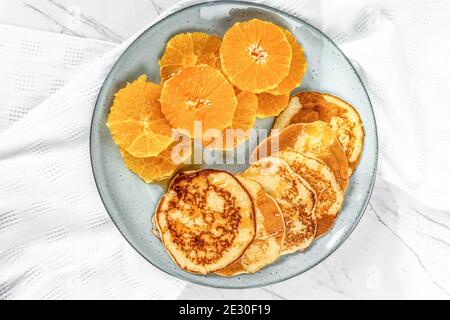 Crêpes américaines et tranches d'orange sur fond de marbre Banque D'Images