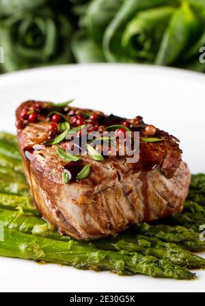 Filet de bœuf au poivre rose et aux asperges. Banque D'Images