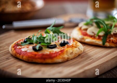 Mini-pizzas servies sur planche en bois. Photo de haute qualité. Banque D'Images