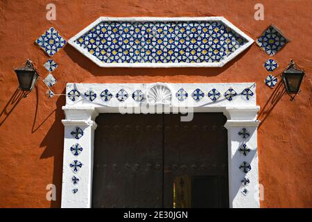 Façade ancienne de maison coloniale avec décorations de carreaux Talavera faites à la main et finitions blanches sur un mur en stuc de terre cuite à Puebla de Zaragoza, Mexique Banque D'Images