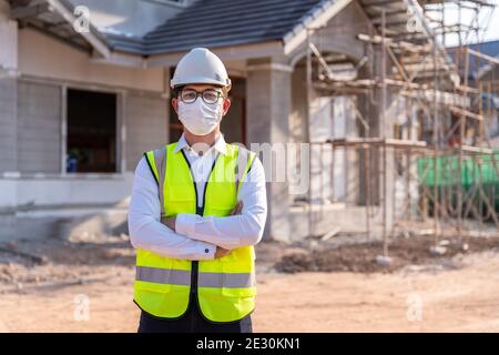 Portrait de l'architecte portant un masque sur un site de construction de bâtiment, idées de construction de maison et prévention de la maladie du coronavirus. Banque D'Images