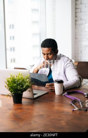 Portrait d'un médecin afro-américain en costume médique de chirurgien étude de l'histoire de la maladie du patient Banque D'Images