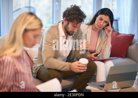 Un groupe de jeunes gens d'affaires lors d'une réunion dans une atmosphère tendue inquiet des résultats d'affaires. Personnes, affaires, réunion Banque D'Images