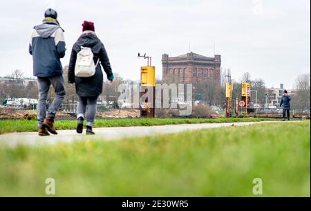 16 janvier 2021, Brême: Par temps nuageux, des poussettes longent la digue Weser en face de la tour d'eau du Werder, connue sous le nom de « mode à l'envers ». Photo: Hauke-Christian Dittrich/dpa Banque D'Images