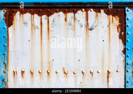Peinture écaillée blanche texture rouille grunge fond d'un panneau texturé en fonte d'époque peint en blanc avec rivets en métal, photo d'image Banque D'Images