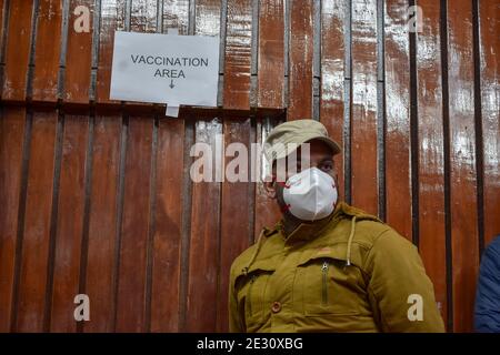 Srinagar, Inde. 16 janvier 2021. Un policier est en alerte à l'extérieur de la salle de vaccination lors d'une campagne de vaccination à Srinagar. Après un an après le début de la pandémie du coronavirus, qui a fait plus de 150.000 morts en Inde, le Premier ministre Narendra Modi a lancé aujourd'hui une campagne nationale de vaccination contre Covid-19. Crédit : SOPA Images Limited/Alamy Live News Banque D'Images