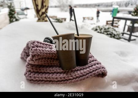 Deux tasses en papier avec café gardent au chaud sur un foulard dans la neige, conte d'amour d'hiver Banque D'Images