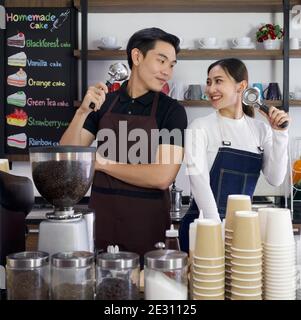Le commerçant et le barista tiennent les porte-filtres Espresso machine avec un sourire. Ambiance matinale dans un café. Banque D'Images