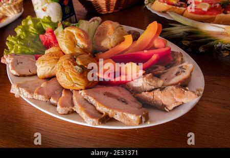 Assiette avec de délicieux en-cas sur une table dans un café. Tapas, hors-d'œuvre à la table du buffet dans un restaurant. Hamburgers, viande farcie cuite au four avec épices, tranche Banque D'Images