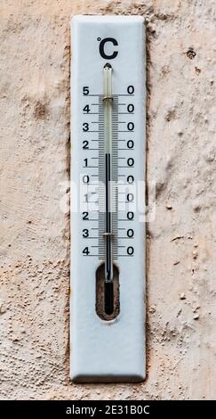 Un thermomètre d'extérieur analogique émaillé blanc indique la température de 17 degrés Celsius Banque D'Images