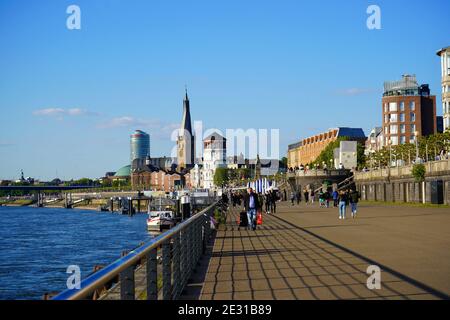 Promenade du Rhin par une journée ensoleillée avec ciel bleu. Tour du château et église de Lambertus en arrière-plan. Banque D'Images