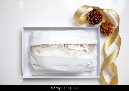 Christstollen Noël gâteau de stollen isolé sur blanc. Pain traditionnel allemand doux enveloppé de papier dans une boîte en carton et décoration de saison. XMA Banque D'Images