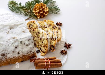 Tranches de Christstollen sur fond blanc. Gâteau de Noël au stollen pain traditionnel allemand sucré, dessert saisonnier avec raisins secs, noix, épices, fr séché Banque D'Images