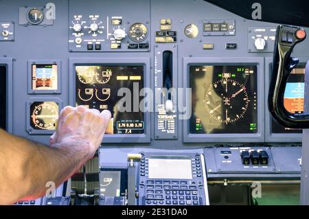 La main du capitaine accélère sur l'accélérateur dans le vol commercial de l'avion de ligne Simulateur - leviers de poussée du cockpit sur la phase de décollage Banque D'Images