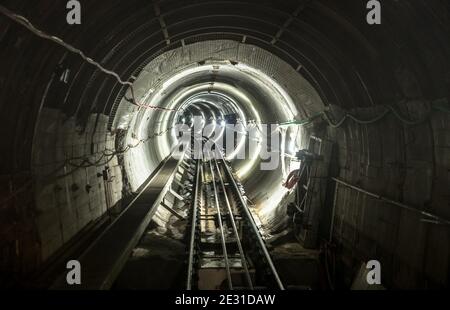 Galerie de tunnels de mine souterraine avec voies ferrées en fonctionnement - Concept industriel avec transport et connexion Banque D'Images