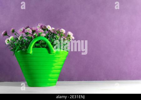 Bouquet de petits chrysanthèmes dans un vase vert sur fond lilas. Carte de vacances et de fleurs. Copier l'espace Banque D'Images