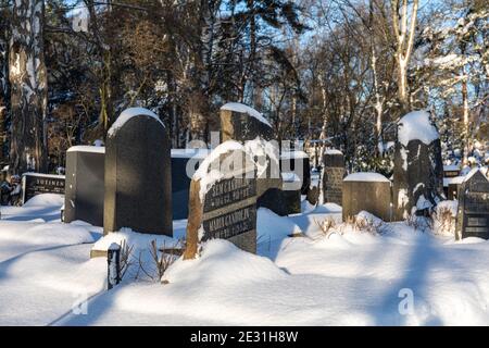 Vieilles tombes et pierres de tête recouvertes de neige dans le cimetière ou cimetière de Hietaniemi à Helsinki, en Finlande Banque D'Images