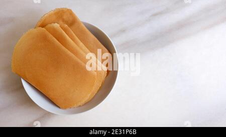 Assiette avec une variation de kuih kapit, un en-cas de galette d'oeufs populaire en Indonésie, Malaisie, Brunei et Singapour. Banque D'Images