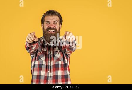 Jeune et brutal. Homme brutal, confiant et beau. Espace pour les copies. Portrait d'un bel homme barbu dans une chemise à carreaux. Homme portant des vêtements décontractés. Homme heureux et brutal avec une barbe debout à l'intérieur. Banque D'Images