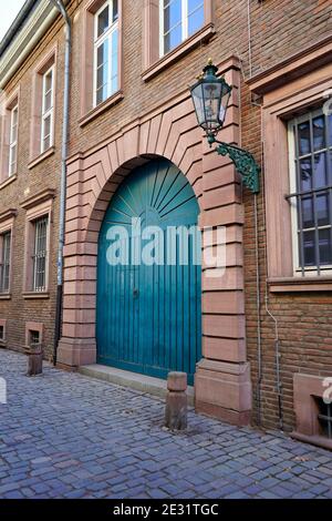 Vieille rue typique de la vieille ville historique de Düsseldorf : ancien bâtiment en brique près du Rhin avec porte bleue, ancienne lanterne à gaz et pavé pavé. Banque D'Images