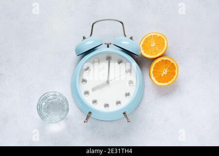 Concept de bonne alimentation portionnée pour la santé calculé par l'horloge. Groupe utile petit déjeuner café, thé, fruits, avoine, noix, lait, eau, muesli. Banque D'Images