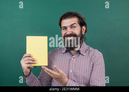 brutal non shaven guy professeur d'université au tableau de surveillance, bibliothèque. Banque D'Images