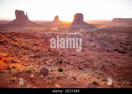 Les célèbres formations rocheuses de West Mitten, East Mitten et Merrick Butte sont rétroéclairées au lever du soleil dans le parc tribal de Monument Valley Navajo, Arizona et Utah, États-Unis Banque D'Images