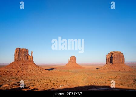 Les formations rocheuses de West Mitten, East Mitten et Merrick Butte au coucher du soleil dans le parc tribal de Monument Valley Navajo, Arizona et Utah, États-Unis Banque D'Images