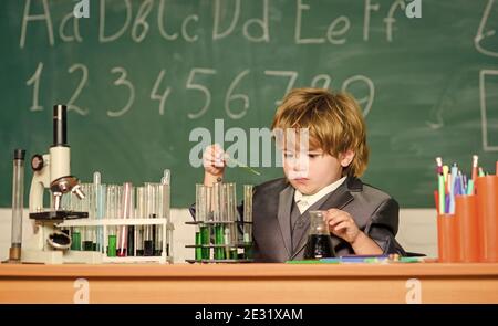 laboratoire de chimie. Retour à l'école. Petit garçon à l'armoire chimique. Un petit enfant qui apprend la chimie dans un laboratoire scolaire. Expérimente avec les produits chimiques Kid en laboratoire qui apprend la chimie du manteau. Très occupé. Banque D'Images