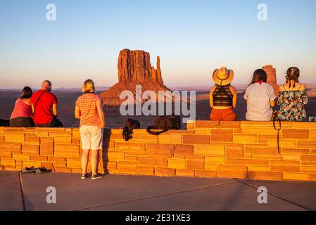 Visiteurs regardant le coucher du soleil sur les formations rocheuses de West Mitten et Merrick Butte dans le parc tribal de Monument Valley Navajo, Arizona et Utah, États-Unis Banque D'Images