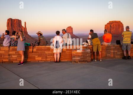 Visiteurs regardant le coucher du soleil sur les formations rocheuses de West Mitten, East Mitten et Merrick Butte à Monument Valley, Arizona et Utah, États-Unis Banque D'Images