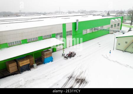 le tracteur nettoie la neige sur la vue de dessus de l'usine. Banque D'Images