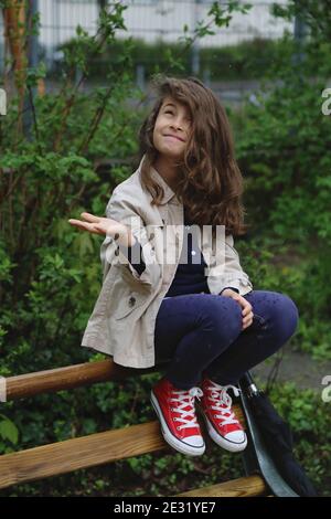 Une fille aux cheveux longs regarde le ciel sous la pluie. Banque D'Images