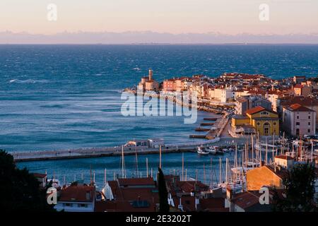 Piran, vieille ville balnéaire pittoresque de Slovénie contre la neige couverte de montagnes des alpes en hiver. Banque D'Images