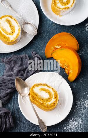 Dessert rouleau de citrouille avec crème au beurre et orange sur fond de béton bleu foncé. Mise au point sélective. Banque D'Images